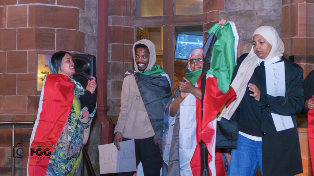 Members of the Sudanese community enjoying a lighter moment outside the Guildhall.